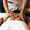 Beautiful young woman having a back massage at health spa.